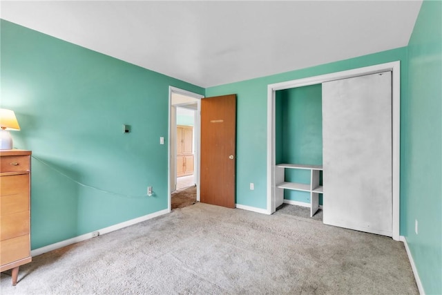 unfurnished bedroom featuring baseboards, carpet floors, and a closet