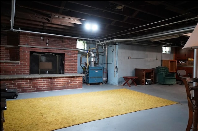 below grade area with heating unit and a brick fireplace