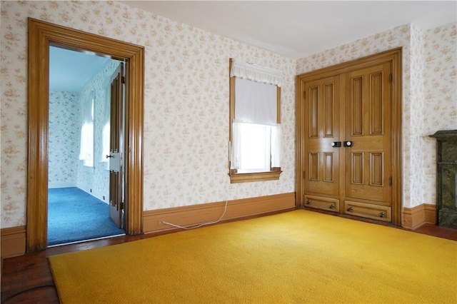 carpeted empty room with wallpapered walls