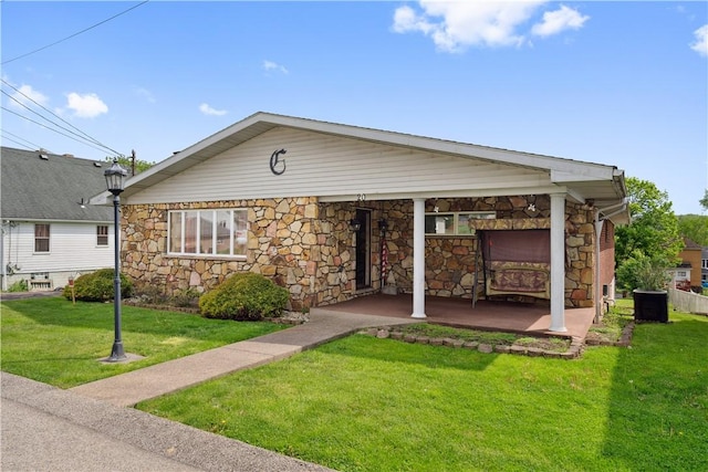 view of front of home with stone siding, a front lawn, and central AC unit