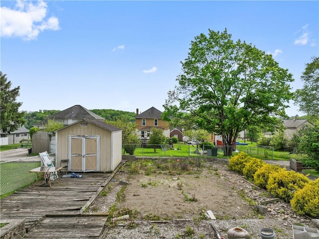 fenced backyard featuring a storage shed, an outbuilding, and a deck