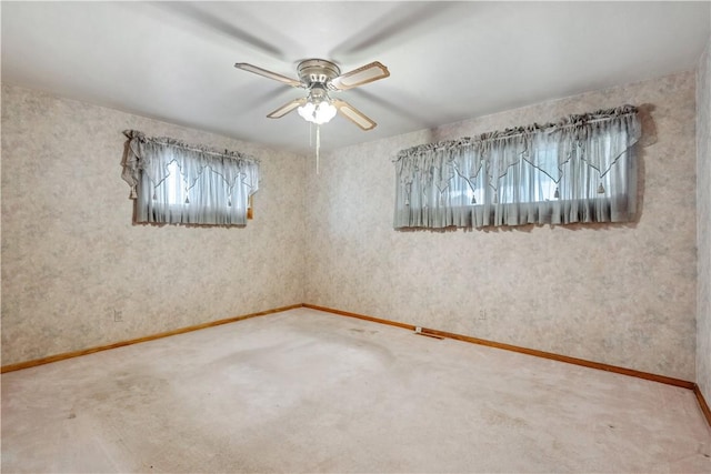 empty room featuring a ceiling fan, carpet flooring, and baseboards