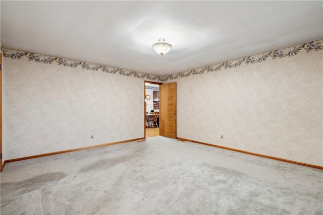 carpeted empty room with baseboards
