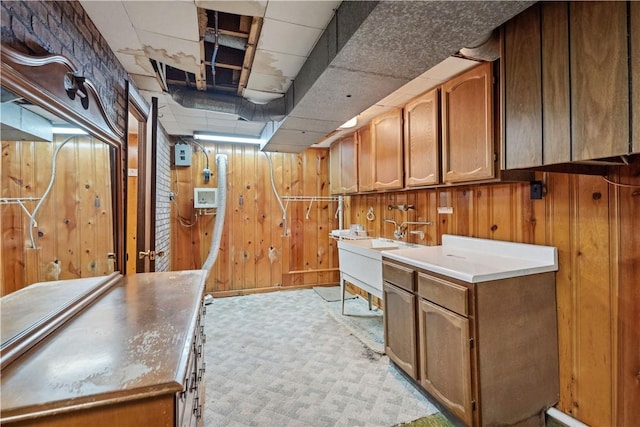 laundry room featuring wooden walls, cabinet space, and light carpet