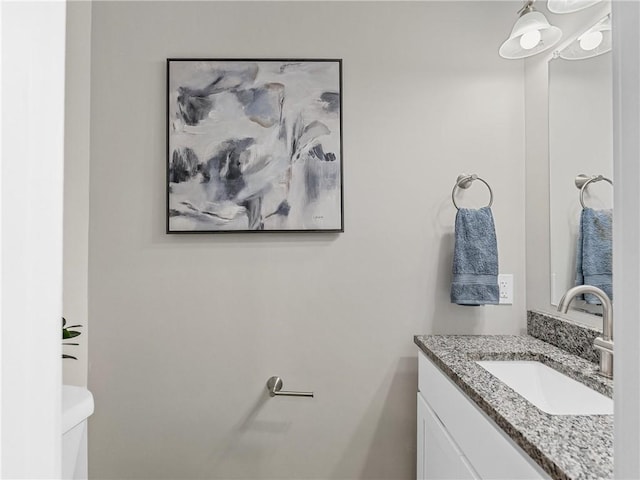 half bath featuring vanity and toilet