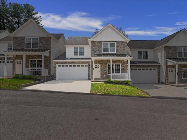 view of front of home with stone siding, a porch, a standing seam roof, and concrete driveway