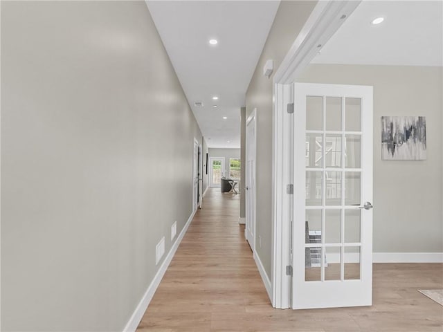 hall with light wood-style floors, recessed lighting, baseboards, and french doors