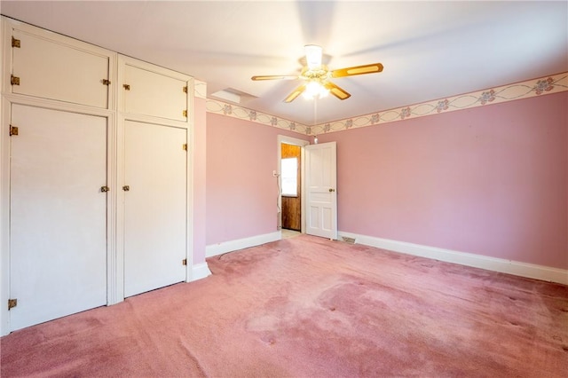 unfurnished bedroom featuring light colored carpet, baseboards, ceiling fan, and a closet