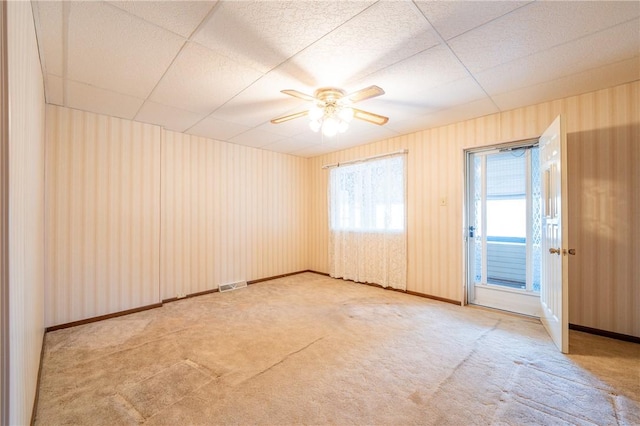 carpeted spare room with ceiling fan and baseboards