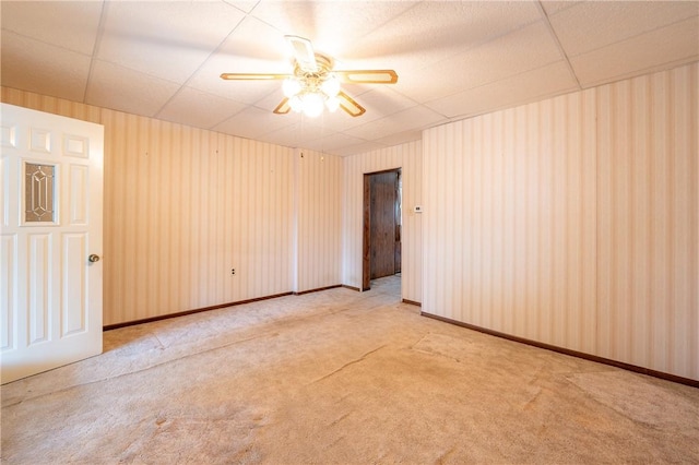 unfurnished room with a ceiling fan, carpet, and a paneled ceiling