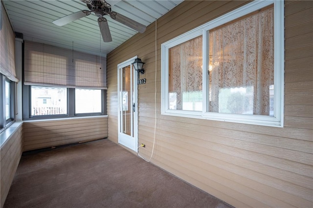 unfurnished sunroom featuring healthy amount of natural light and a ceiling fan