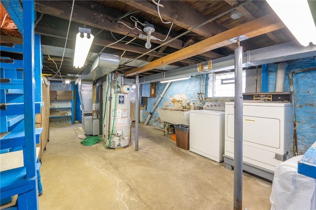 basement with water heater, washing machine and dryer, and a sink