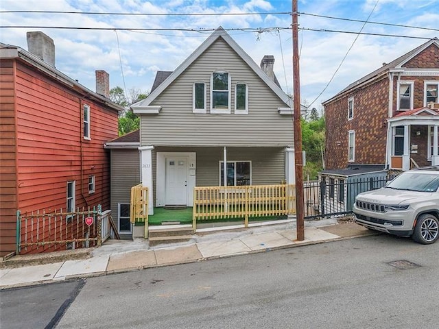 view of front of property featuring covered porch and fence