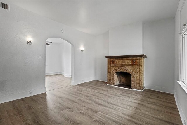 2633 S 18th St, Mount Oliver, PA 15210 - unfurnished living room featuring arched walkways, wood finished floors, a fireplace, and baseboards