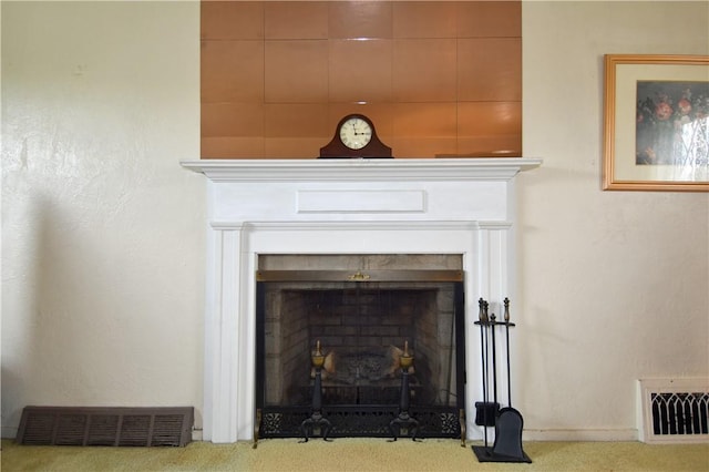 detailed view of a fireplace with flush hearth and carpet flooring