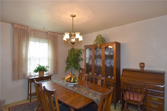 dining room with a chandelier and baseboards