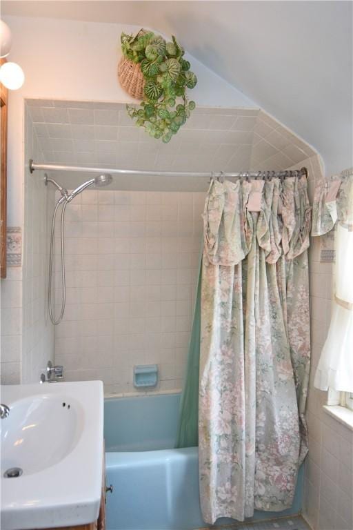 full bath with shower / bath combo with shower curtain and a sink