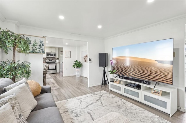 living room with ornamental molding, light wood-style flooring, recessed lighting, and baseboards