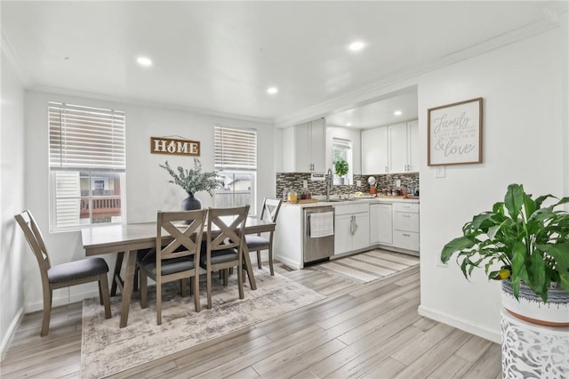 dining area featuring crown molding, baseboards, light wood-style flooring, and recessed lighting