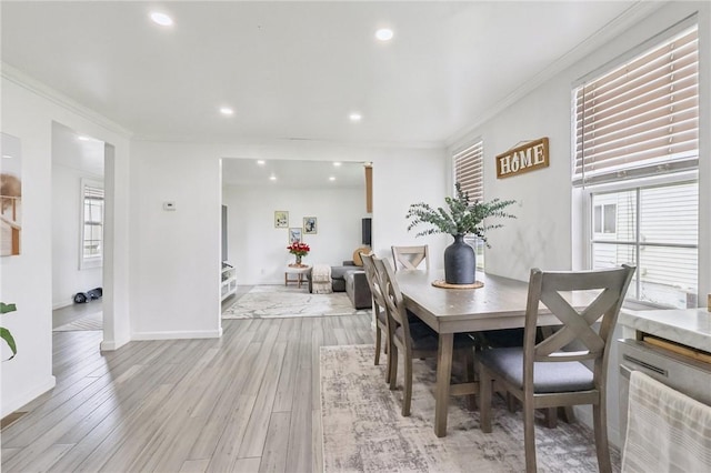 dining space featuring ornamental molding, light wood-style floors, recessed lighting, and baseboards