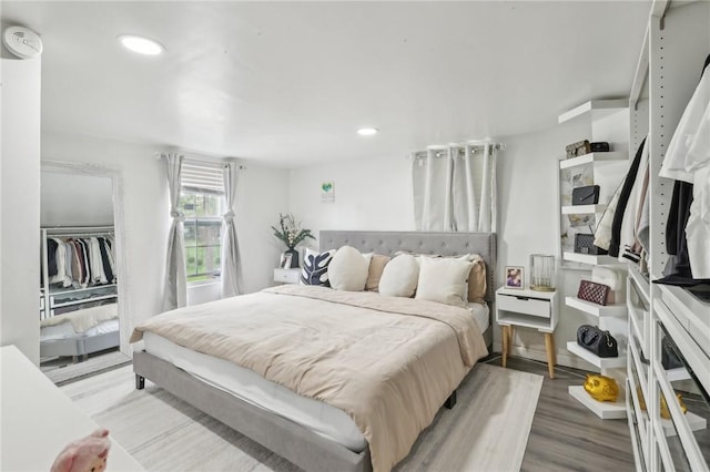bedroom featuring light wood-style flooring, recessed lighting, and a closet