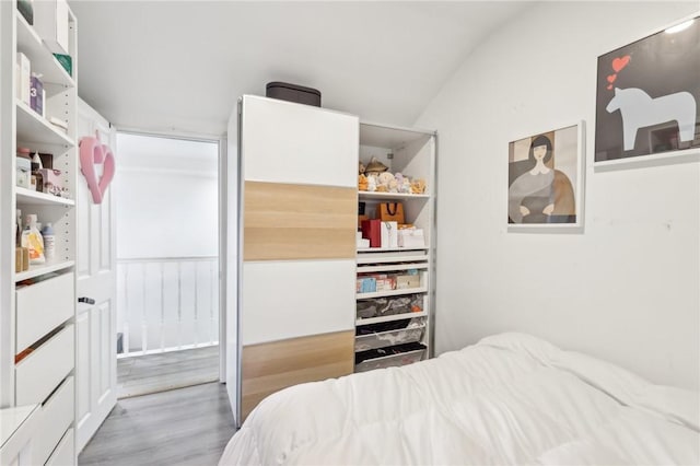 bedroom featuring wood finished floors and vaulted ceiling