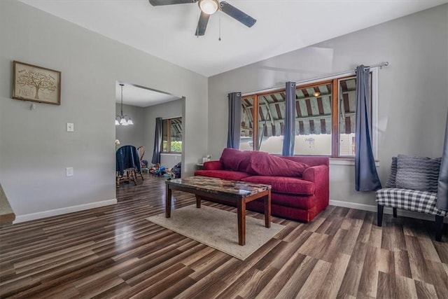 living room with wood finished floors, a ceiling fan, baseboards, and a chandelier