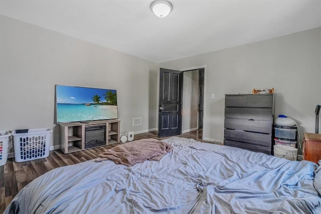 bedroom with wood finished floors and baseboards