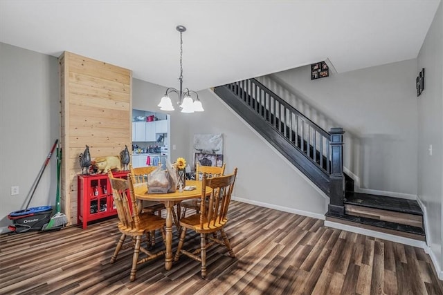 dining room with wood finished floors, a chandelier, stairway, and baseboards