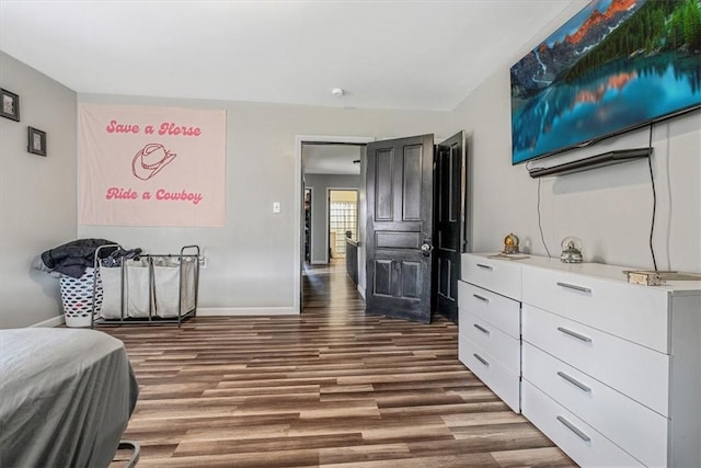 bedroom with wood finished floors and baseboards