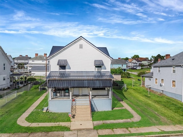 back of property featuring metal roof, a porch, a residential view, and stairs
