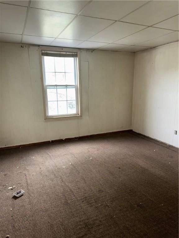 unfurnished room with a drop ceiling, carpet flooring, and baseboards