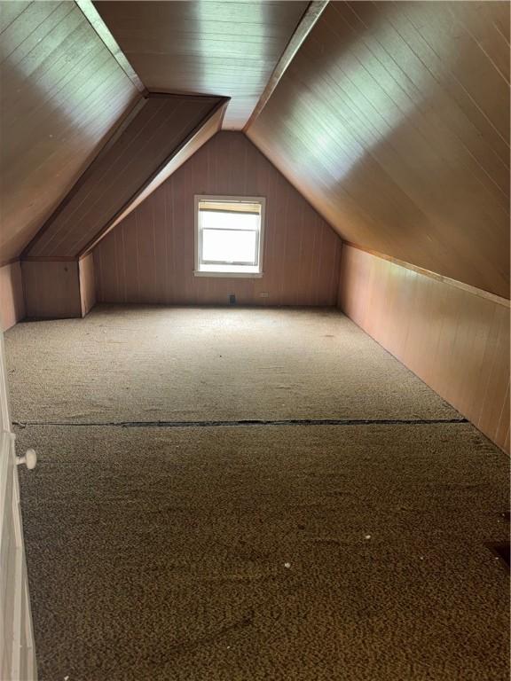 bonus room featuring vaulted ceiling, carpet, wood walls, and wood ceiling