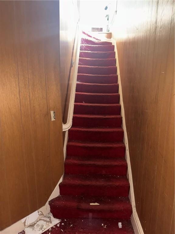 stairs featuring wood walls