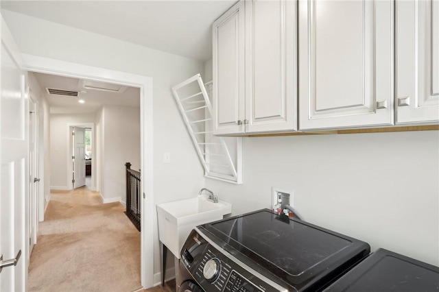 washroom featuring light carpet, washer / clothes dryer, baseboards, and cabinet space