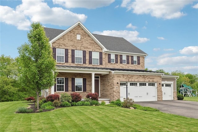 view of front of property with brick siding, driveway, a front lawn, and an attached garage