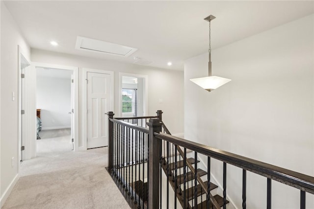 hall featuring an upstairs landing, light carpet, recessed lighting, and baseboards