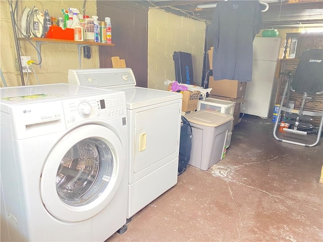 laundry area with separate washer and dryer and concrete block wall