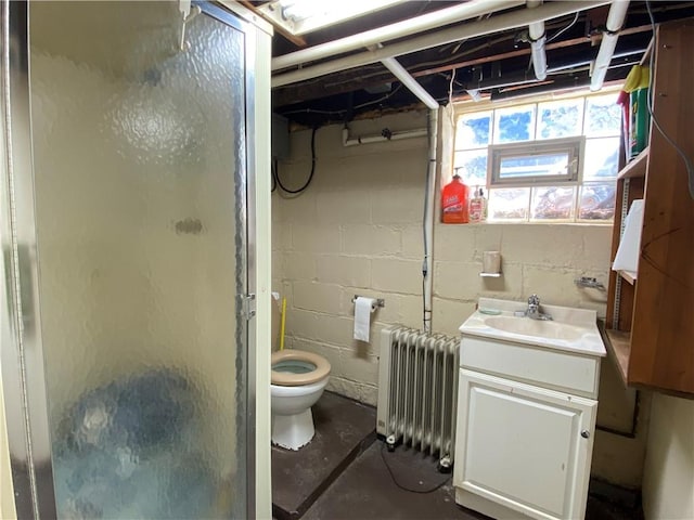 bathroom with radiator heating unit, a shower stall, concrete floors, toilet, and vanity