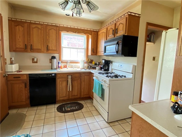 kitchen with black appliances, a sink, and brown cabinetry