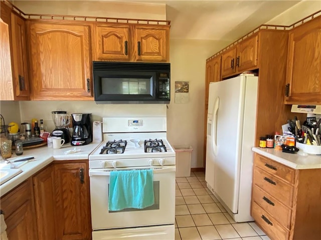 kitchen with white appliances, light countertops, light tile patterned floors, and brown cabinets