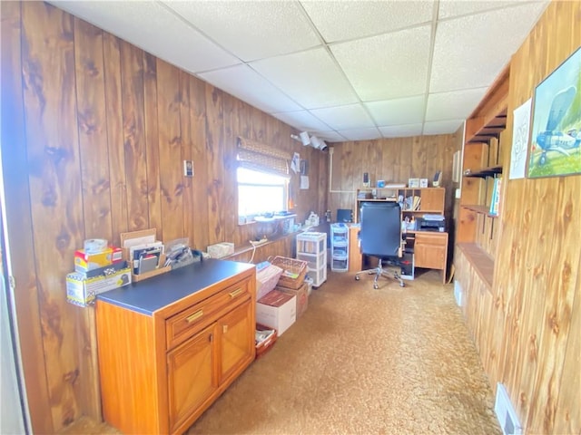 home office featuring wood walls and a paneled ceiling