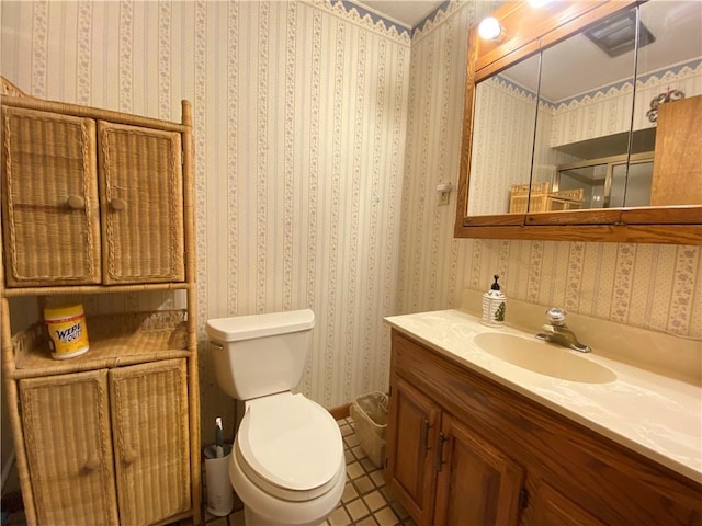 bathroom featuring wallpapered walls, toilet, and vanity