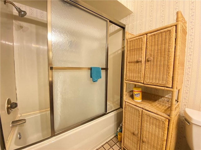 full bathroom featuring wallpapered walls, shower / bath combination with glass door, and toilet