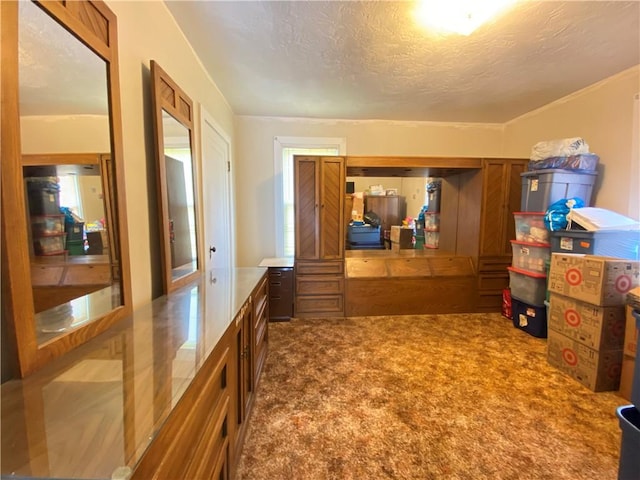 corridor with a textured ceiling and carpet floors
