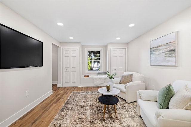living room featuring light wood-style floors, baseboards, and recessed lighting