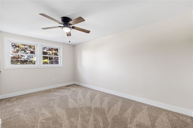 carpeted empty room with baseboards and a ceiling fan