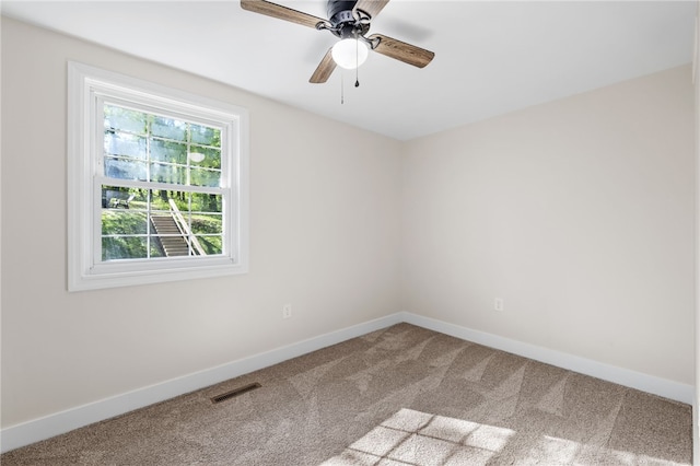 carpeted spare room with baseboards and a ceiling fan