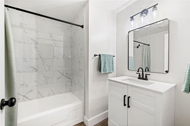 bathroom featuring shower / bath combo with shower curtain, vanity, and baseboards