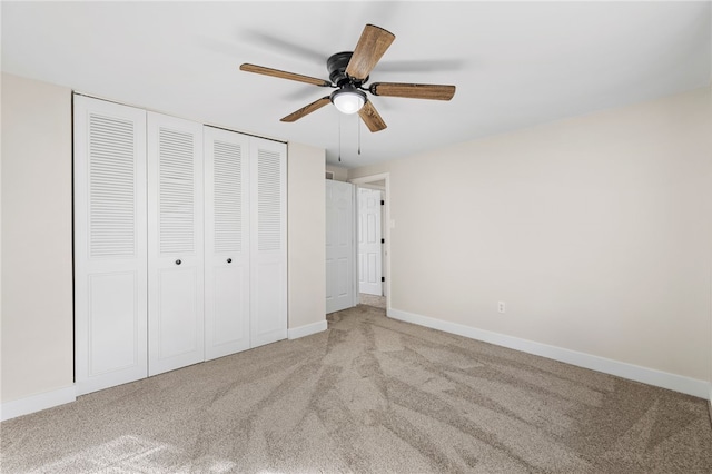 unfurnished bedroom featuring carpet floors, baseboards, a closet, and a ceiling fan